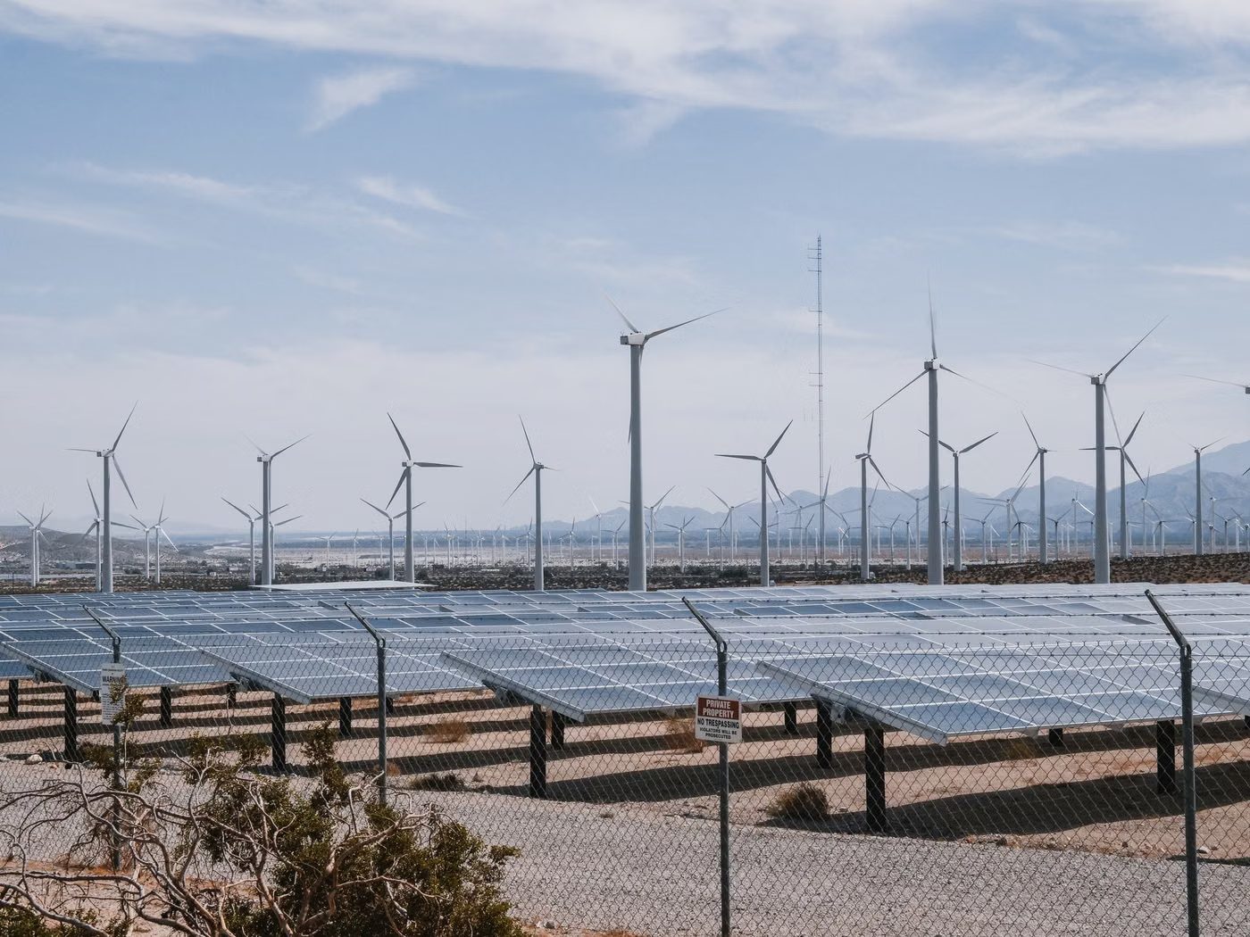 Wind turbines and solar panels under a clear sky